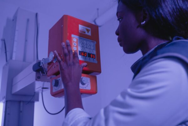 Tecnologa em radiologia operando um equipamento de raios X