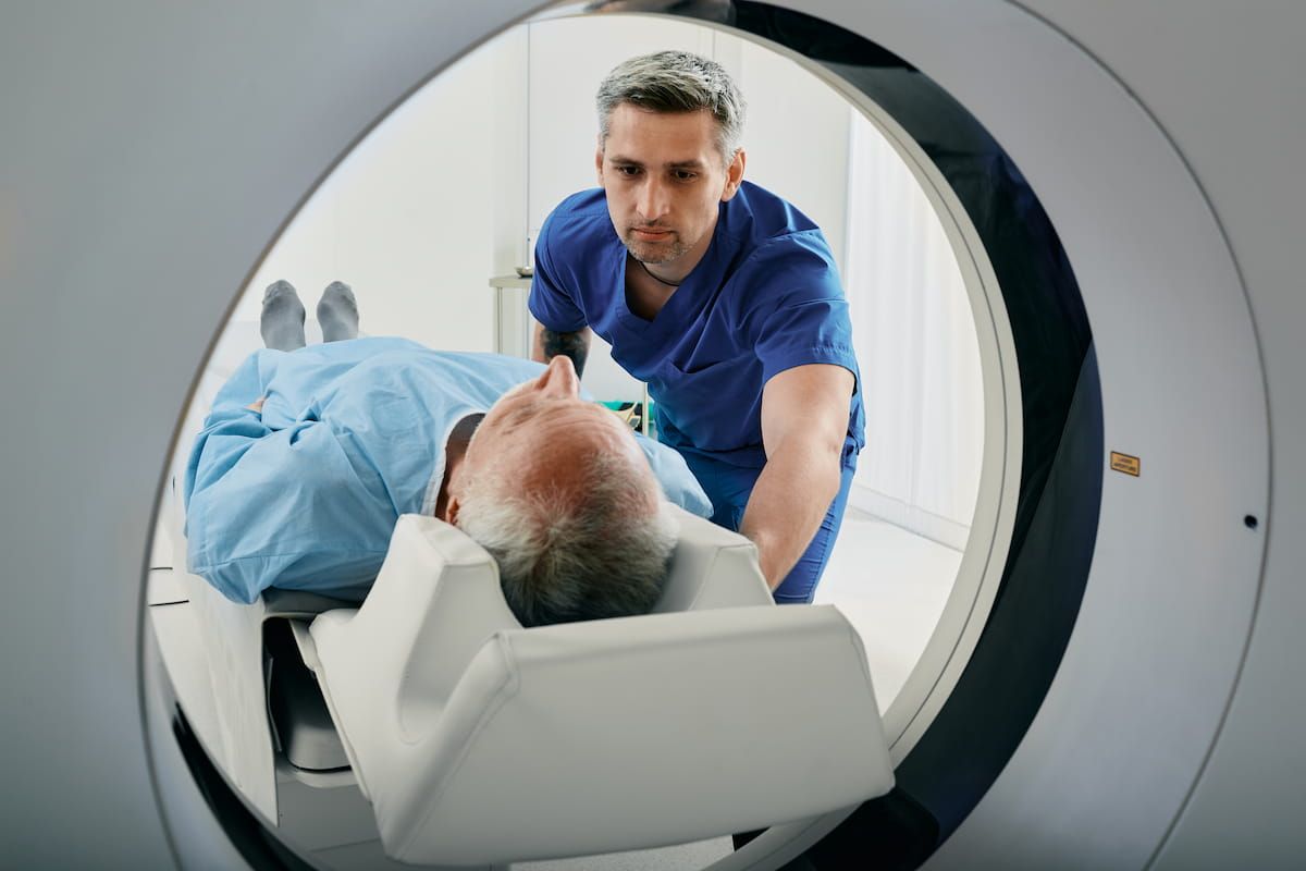 Tecnologo coloca a un paciente en un tomografo de TC; un estudio nacional muestra la caida de la dosis de radiacion
