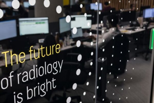 Sala de laudos de teleradiologia da Everlight Radiology com radiologistas em estacoes de multiplos monitores