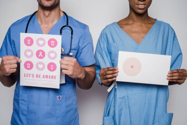 Profissionais de saude segurando material educativo sobre deteccao precoce do cancer de mama