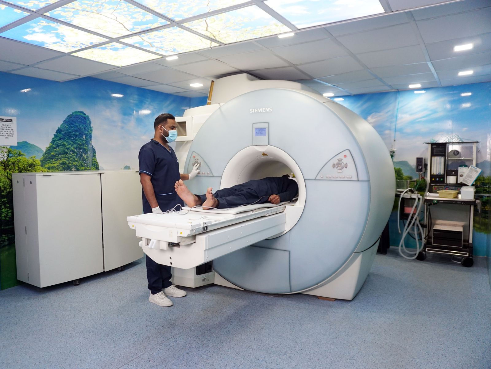 Tecnólogo posiciona paciente em aparelho de ressonância magnética em centro de diagnóstico por imagem